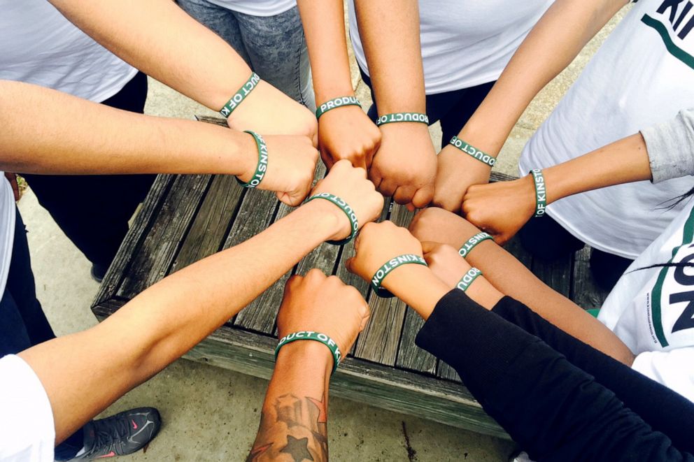 PHOTO: Kinston Teens put their first together after a long day of community work.