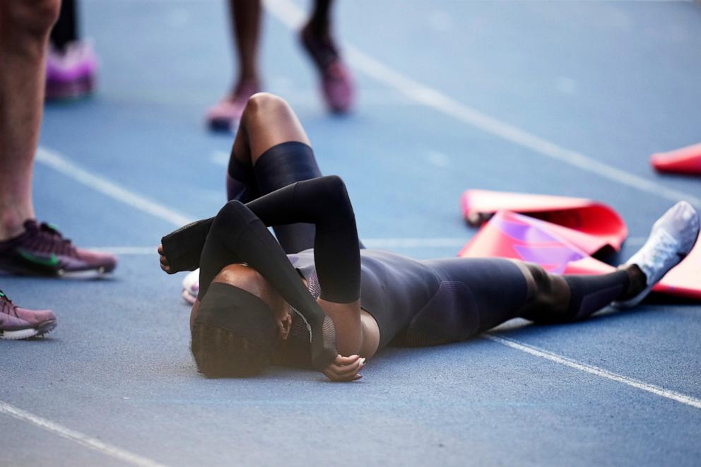 PHOTO: Faith Kipyegon, from Kenya, lies on the track after crossing the finish line in her attempt to become the first woman to run a mile in under four minutes, at Stade Charlety in Paris, June 26, 2025. 