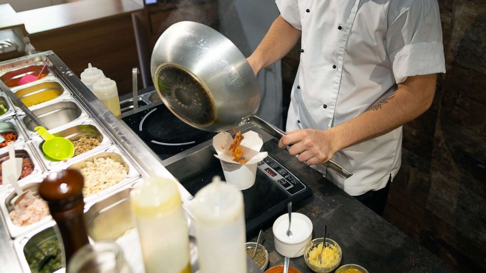 PHOTO: A man wearing a face mask cooks at a restaurant in an undated stock photo.