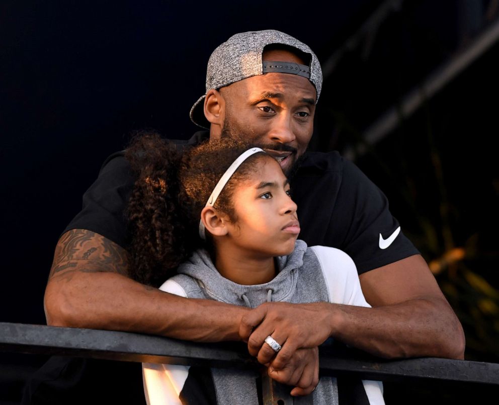 PHOTO: Kobe Bryant and daughter Gianna Bryant watch the National Swimming Championships at the Woollett Aquatics Center on July 26, 2018, in Irvine, Calif.