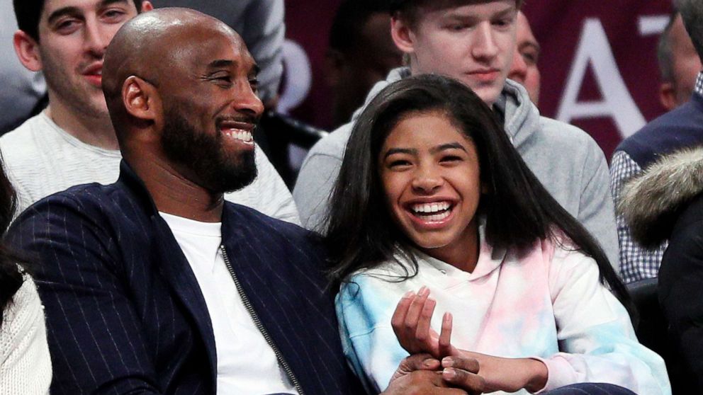 PHOTO: Retired NBA star Kobe Bryant and his daughter Gigi, watch an NBA basketball game, Dec. 21, 2019, at Barclays Center in New York City.