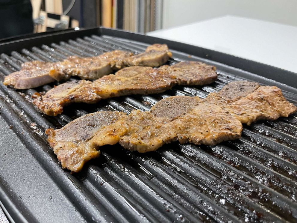 PHOTO: Marinated Korean short ribs cook on the grill.