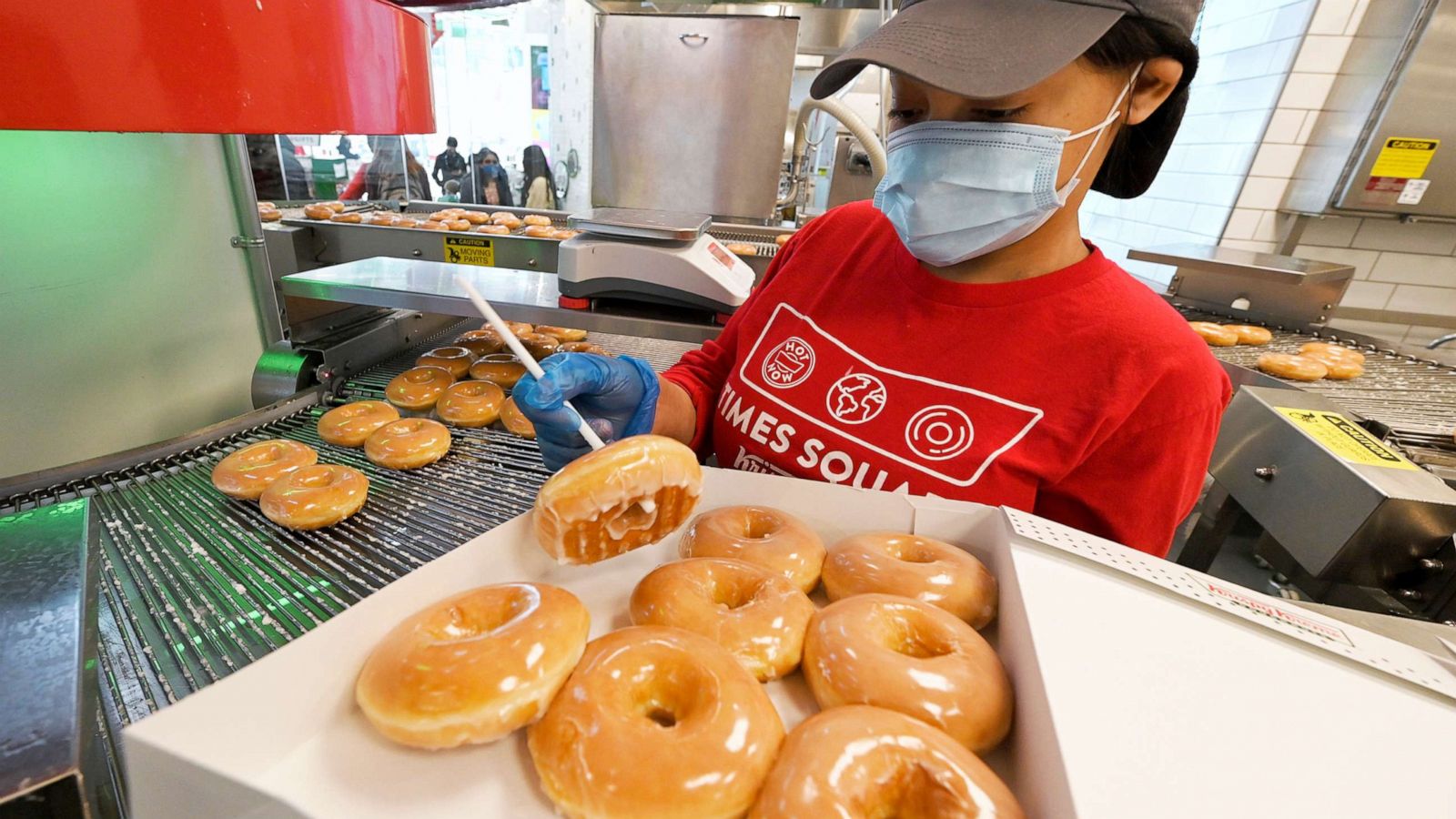 PHOTO: In this March 30, 2021, file photo, a worker prepares a box of a dozen donuts inside the Krispy Kreme Times Square flagship store in New York.