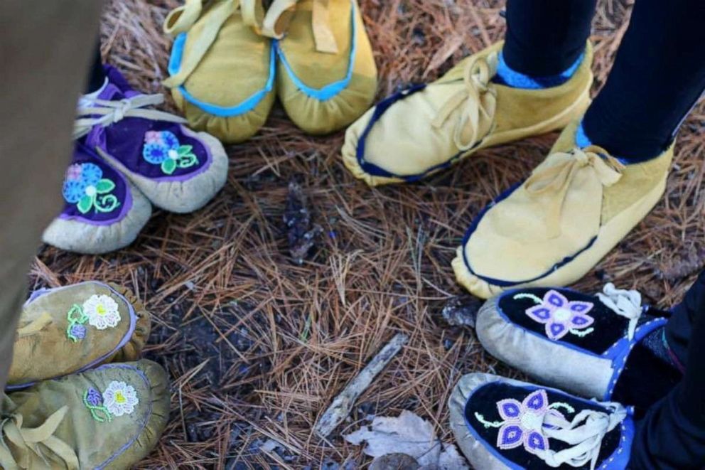 PHOTO: KwePack runners wearing moccasins stand in a circle in an undated handout photo.