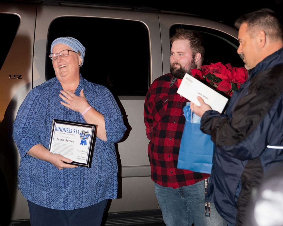 PHOTO:  Laurie Burpee, far left, reacts to being presented with a Kindness 911 citation.