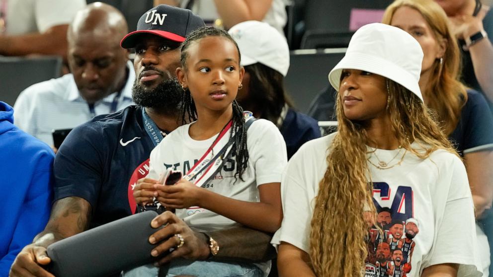 PHOTO: LeBron James of the U.S. sits with his daughter, Zhuri Nova James and wife Savannah James while watching the women's gold medal game, at the 2024 Paris Olympics, Aug. 11, 2024.