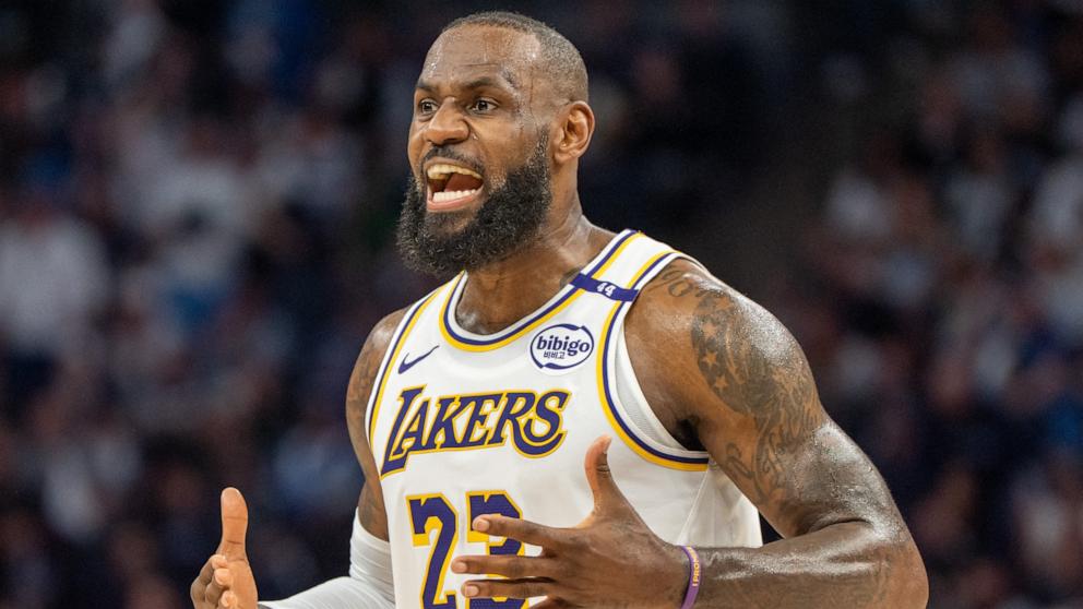 PHOTO: Los Angeles Lakers forward LeBron James talks with his coach during a stoppage in play against the Minnesota Timberwolves in Minneapolis, April 27, 2025.