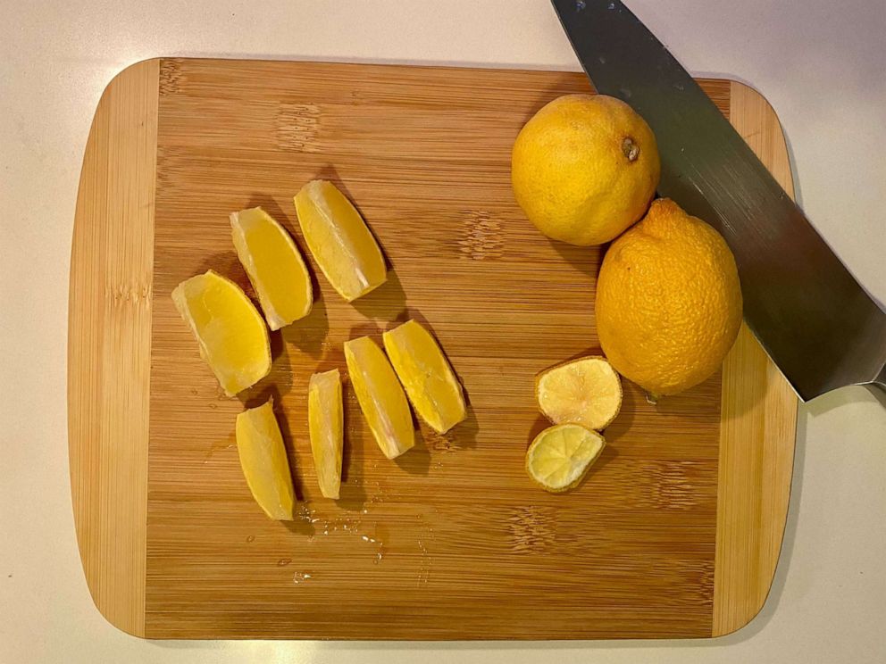 PHOTO: Fresh lemon wedges sliced on a small bamboo cutting board.
