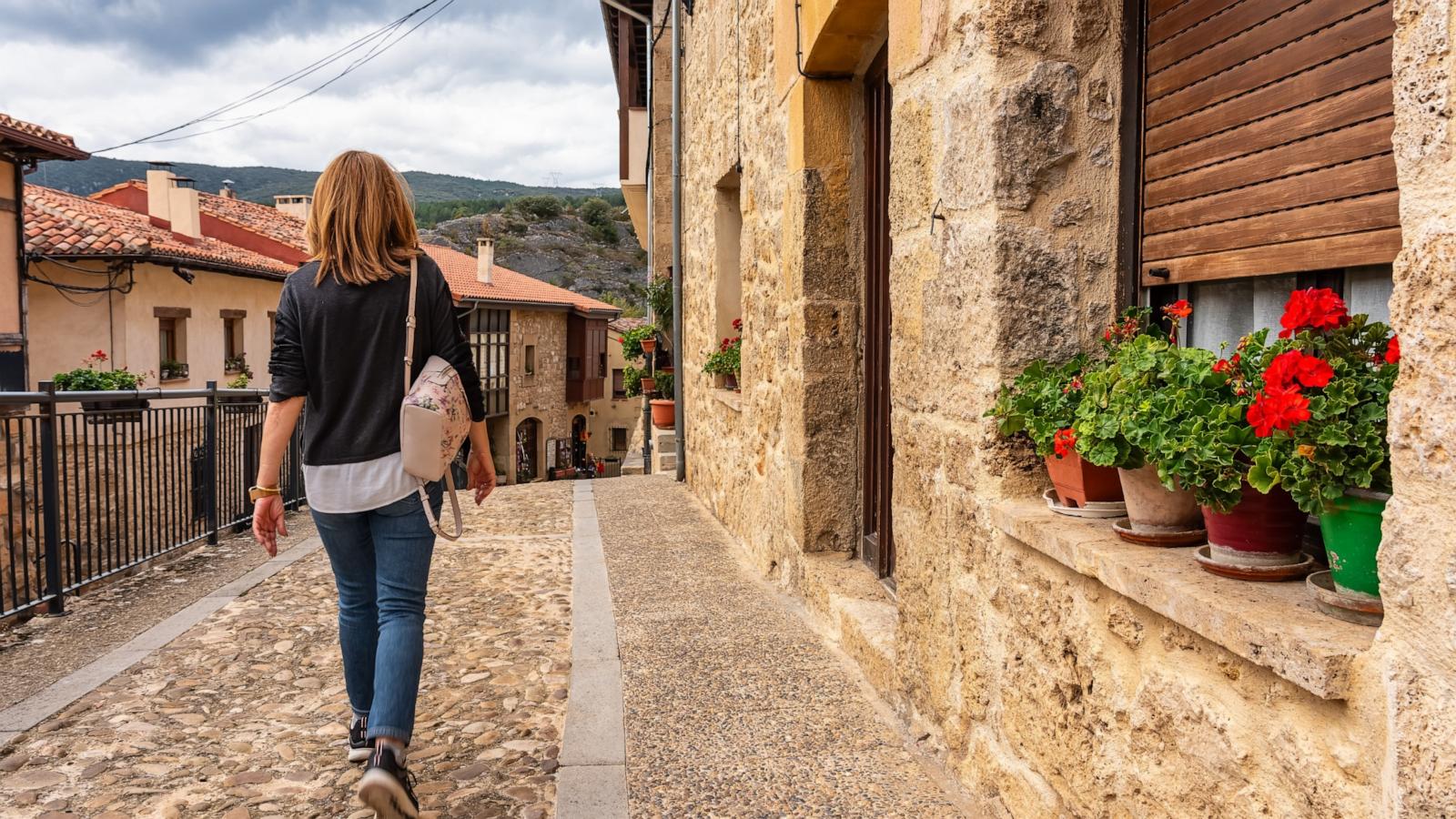 PHOTO: Tourist woman walking through the cobbled streets of the medieval village of Frias, Burgos.