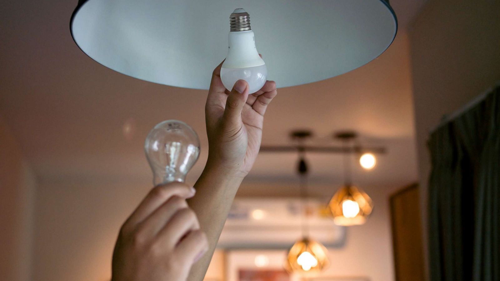 PHOTO: Stock photo of a person changing a lightbulb.