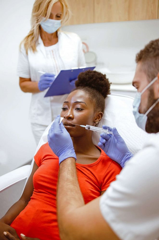 PHOTO: A woman receives hyaluronic filler injection treatment on her lips in this stock image.