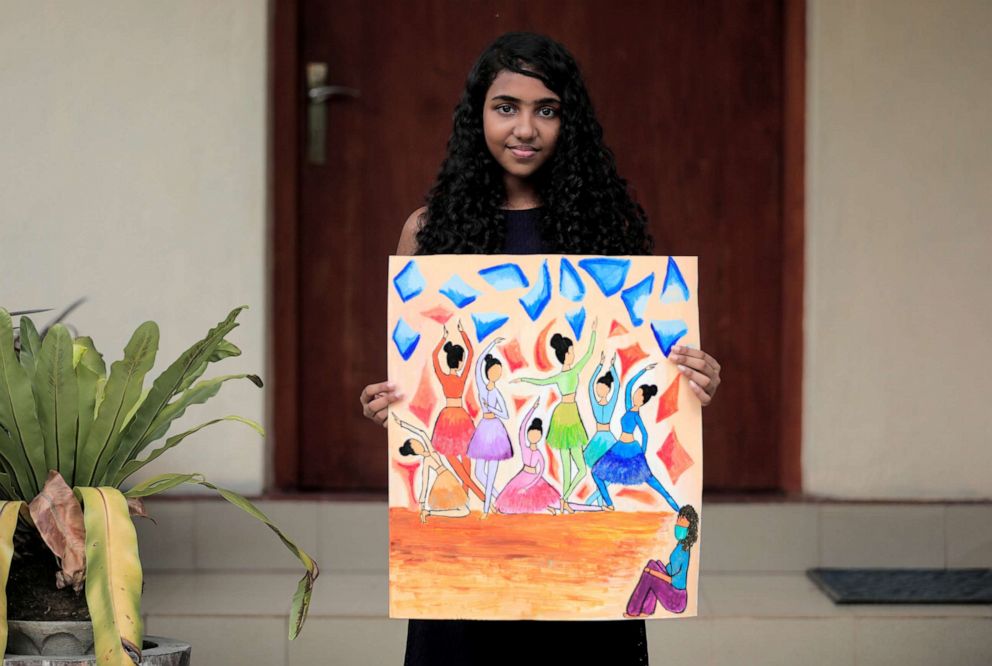 PHOTO: Sandithi Illeperuma, 14, poses for a photograph while holding a picture that she drew during the coronavirus disease (COVID-19) outbreak, as she stands in front of her home in Colombo, Sri Lanka, April 17, 2020.