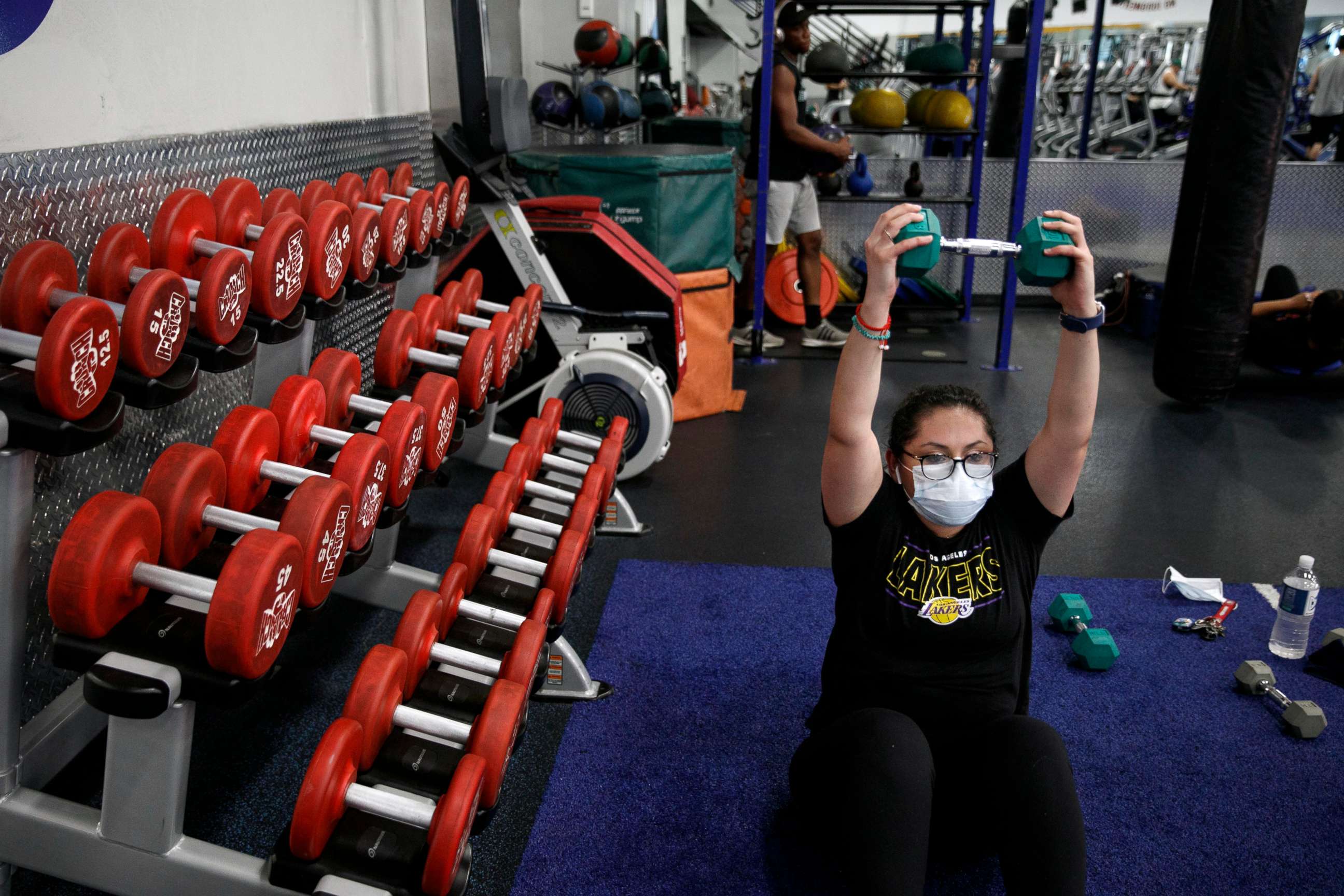 PHOTO: In this June 26, 2020, file photo, a woman wears a mask while exercising at a gym in Los Angeles.