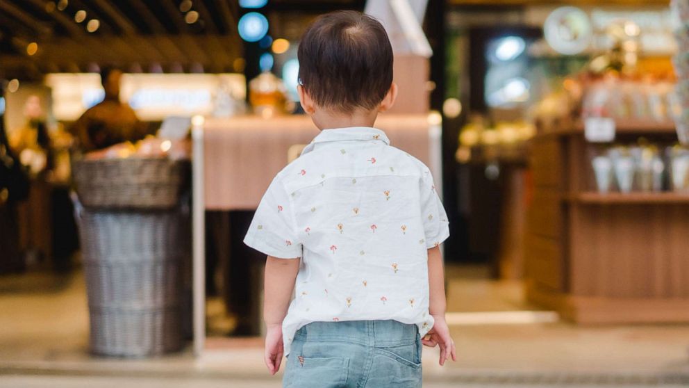 A toddler is pictured standing alone and without his parents in shopping mall, in this stock image.