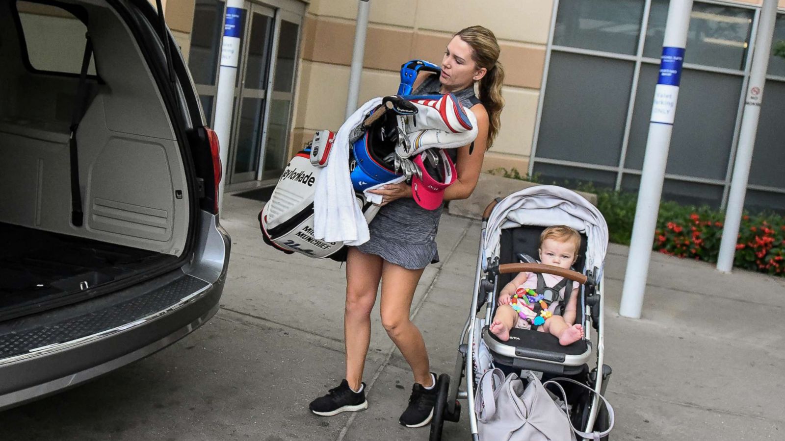 PHOTO: Sydnee Michaels loads her golf clubs into the car alongside her 9-month-old baby Isla before they head to the Indy Women in Tech Championship Pro-Am, Wednesday, Aug. 15, 2018, Indianapolis.