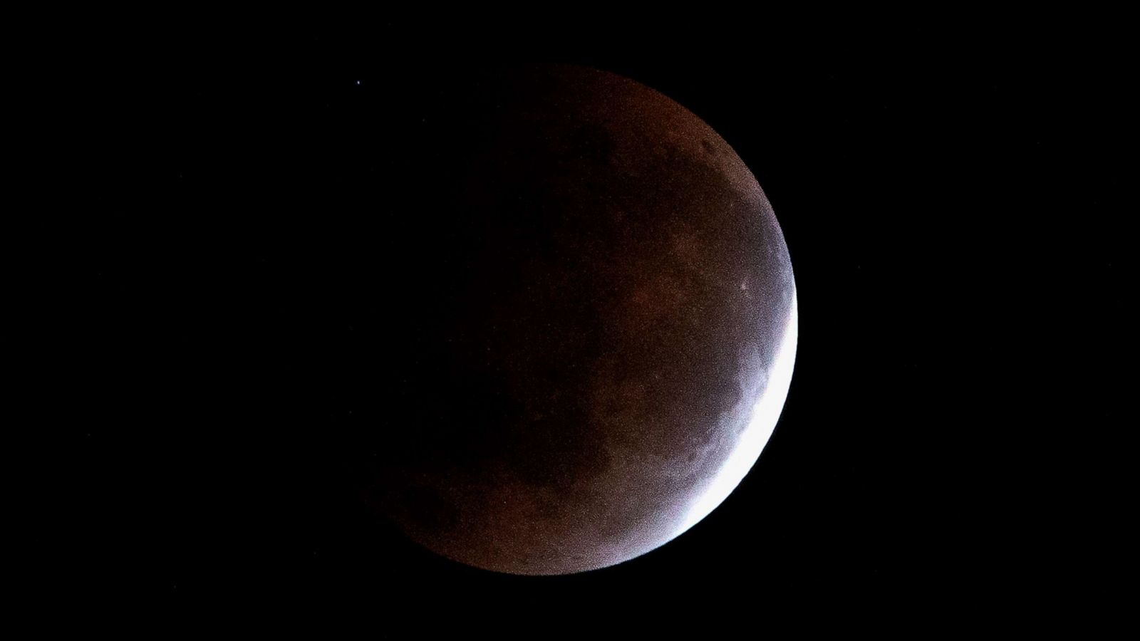 PHOTO: The moon is pictured above Suva in Fiji on May 26, 2021, during a total lunar eclipse as stargazers across the Pacific casted their eyes skyward to witness a rare "Super Blood Moon."