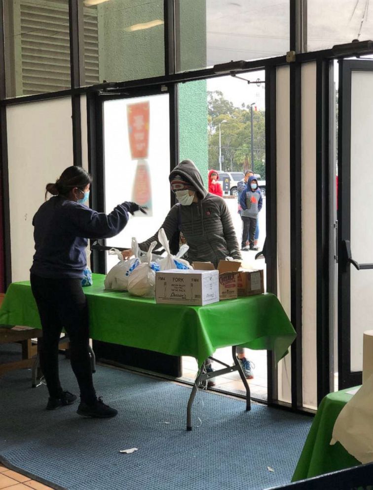 PHOTO: A staff member from Arts in Action Community Charter Schools in East Los Angeles hands out free packaged lunches the pandemic.