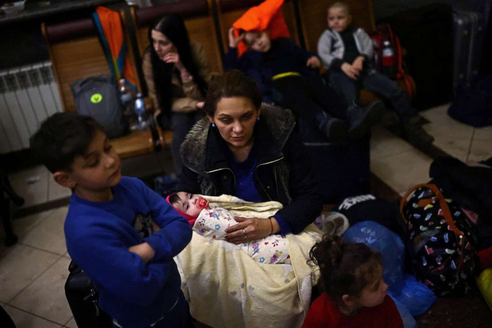 PHOTO: A family who fled Russia's military campaign against Ukraine waits at the train station in Lviv, Ukraine, hoping to board a train to Poland, Feb. 28, 2022.