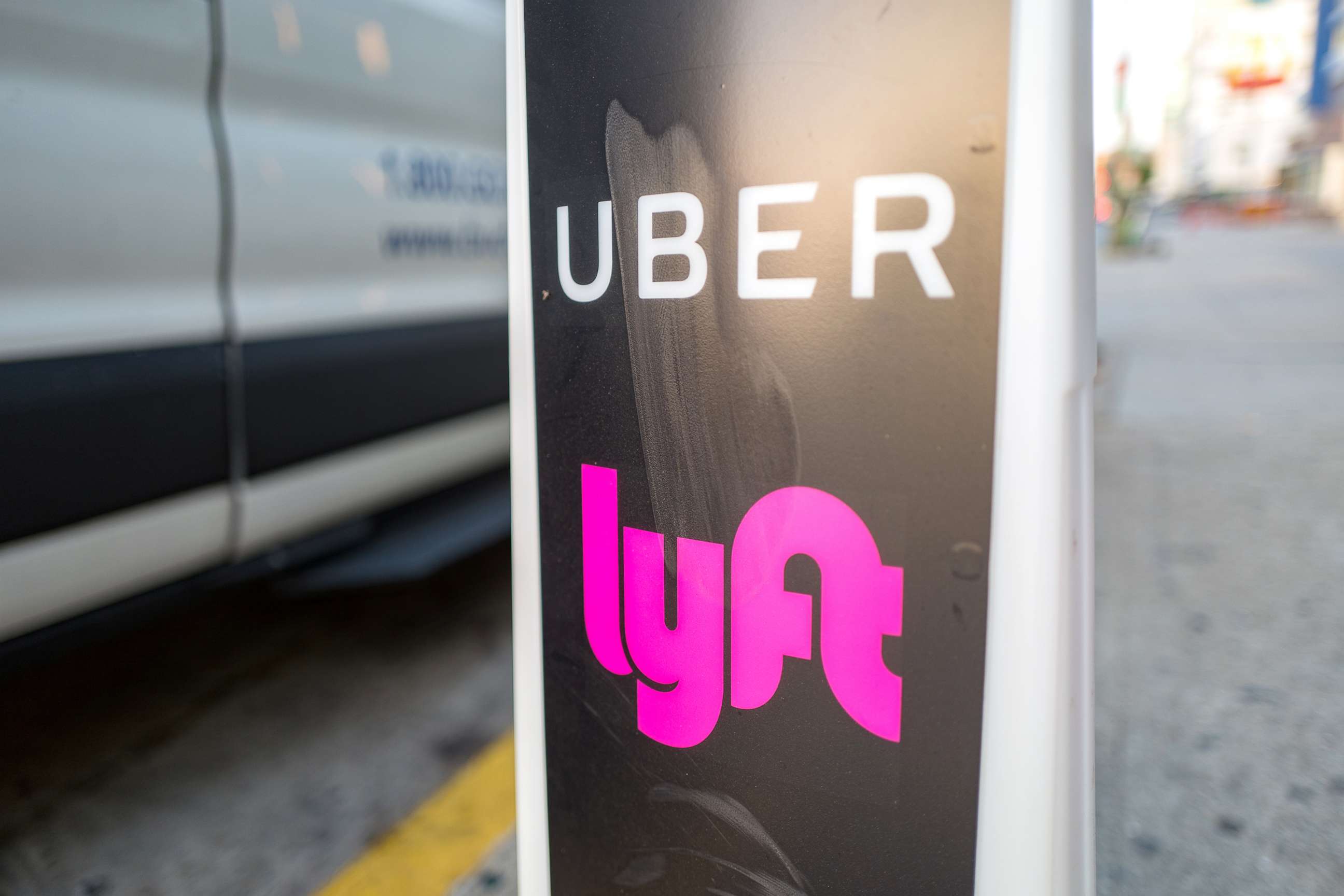 Close-up of vertical sign with logos for ridesharing companies Uber and Lyft indicating a location where rideshare pickups are available in downtown Los Angeles, Oct. 24, 2018.