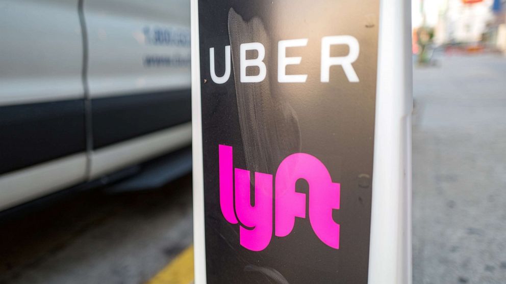 Close-up of vertical sign with logos for ridesharing companies Uber and Lyft indicating a location where rideshare pickups are available in downtown Los Angeles, Oct. 24, 2018.