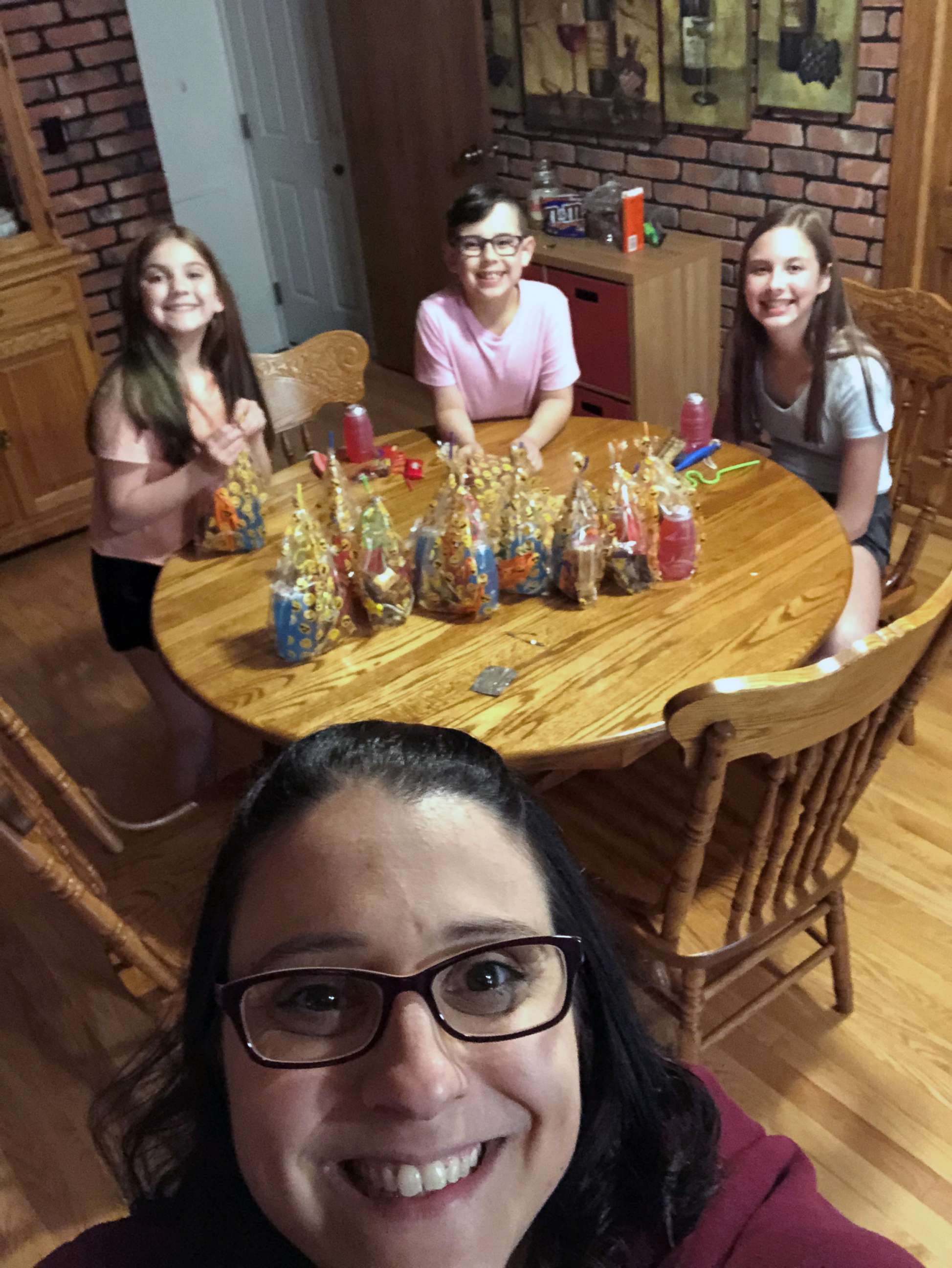 PHOTO: Lyssa McClenahan, of Canton, Michigan, poses with her kids as they make gift baskets for the Sisterhood of the Traveling Wine.