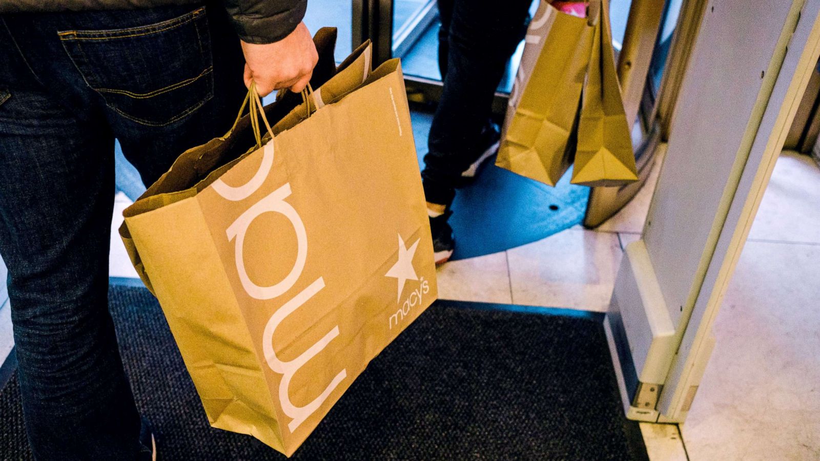 PHOTO: People carrying shopping bags exit Macy's flagship store in Herald Square in New York City, Nov. 27, 2020.