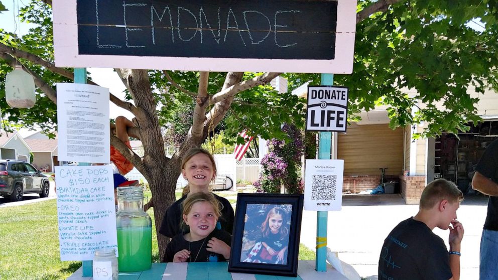 Myleigh Madsen, 9, and Makayla Madsen, 7, are running a lemonade stand outside of their home in West Jordan, Utah, in honor of their sister, Makenzie, who died waiting for a heart and kidney transplant.