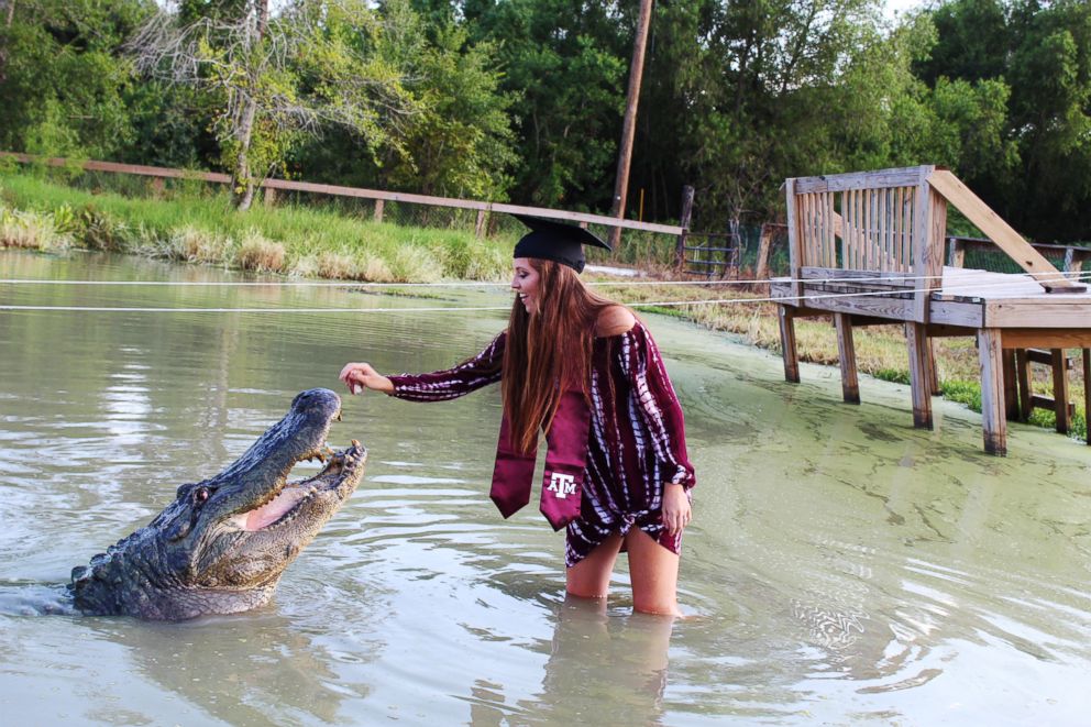 PHOTO: Makenzie Holland took her Texas A&M graduation photos with "Big Tex" a gator she bonded with while interning at Gator Country Rescue.