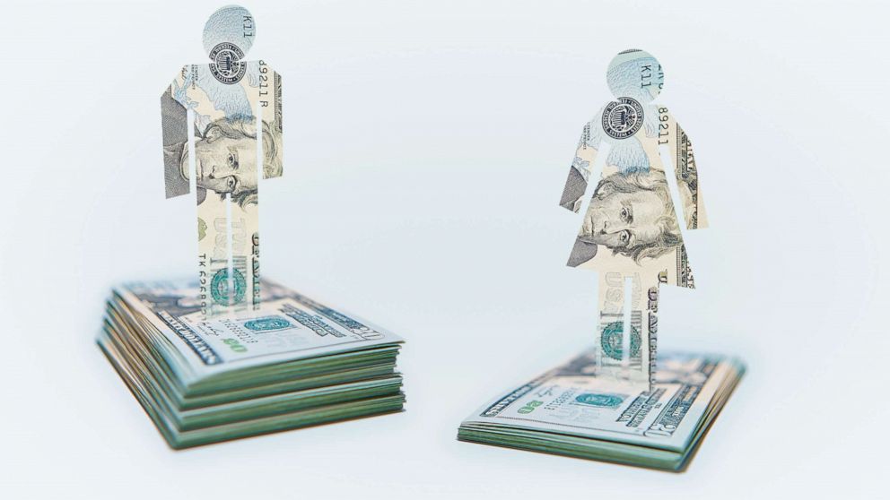 PHOTO: A male and a female figure is seen on a pile of money in this stock photo.