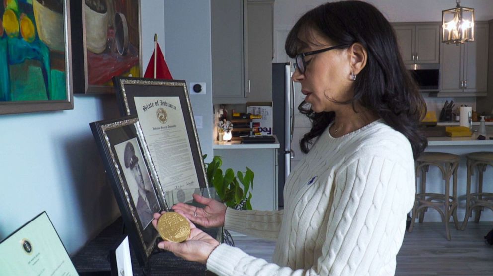 PHOTO: Mallorie Berger, the granddaughter of a Montford Point Marine, holds a replica of the Congressional Gold Medal collectively to the unit in 2011.