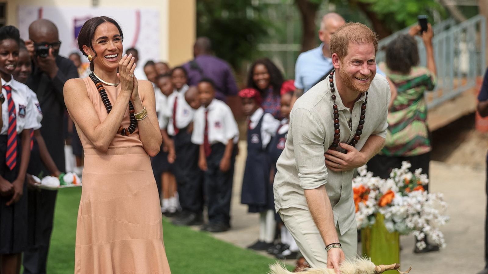 PHOTO: Britain's Prince Harry (R), Duke of Sussex, and Britain's Meghan (L), Duchess of Sussex, take part in activities as they arrive at the Lightway Academy in Abuja on May 10, 2024.