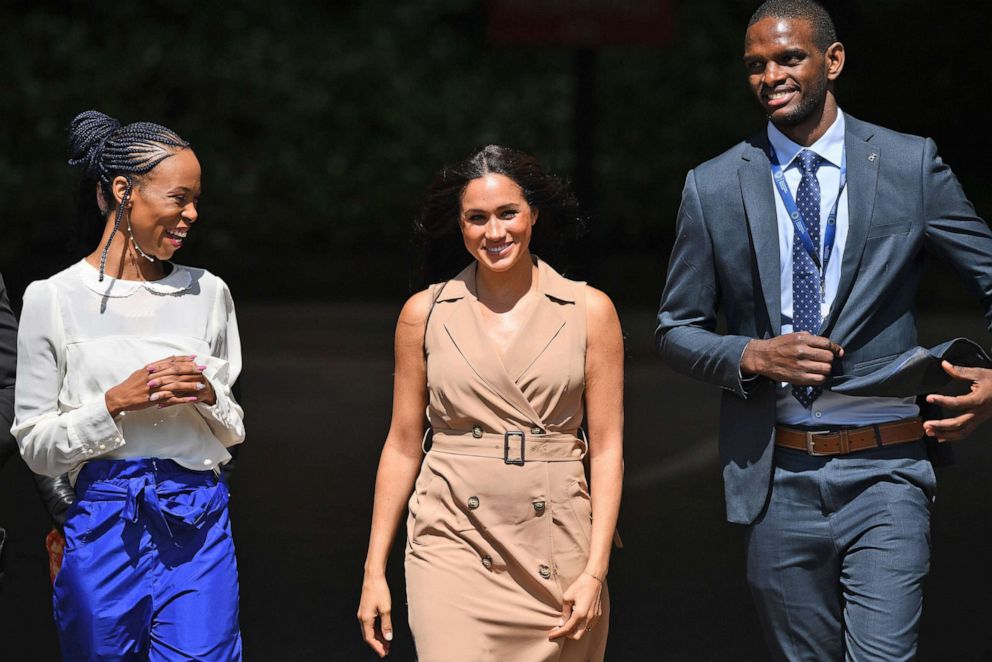 PHOTO: Meghan, the Duchess of Sussex, center, is accompanied by two unidentified officials during a visit to the University of Johannesburg, in Johannesburg, South Africa, Oct. 1, 2019.