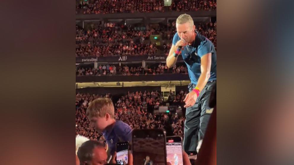 PHOTO: Chris Martin stops to help a young fan during a Coldplay concert on Nov. 6, 2024, at Accor Stadium in Sydney.