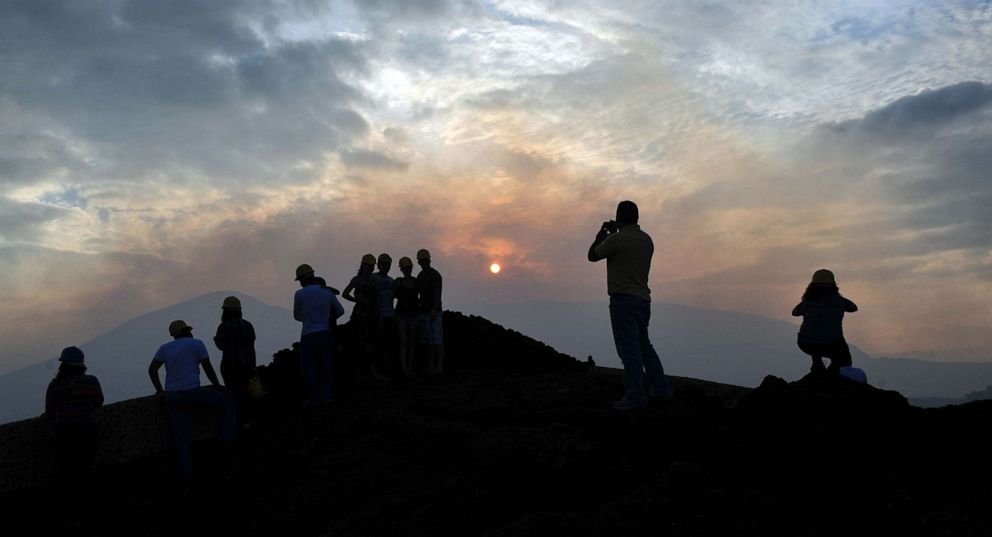 PHOTO: Tourists pose for photos next to the Masaya volcano crater at Masaya Volcano National Park, Nov. 10, 2012.