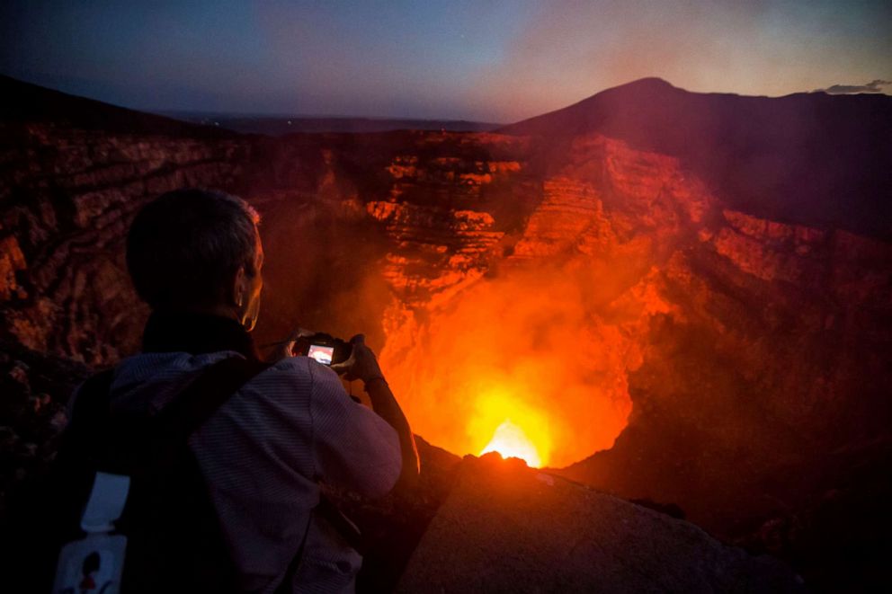PHOTO: A tourist takes pictures of a lava lake inside the crater of the Masaya Volcano in Masaya, May 19, 2016, in Nicaragua.