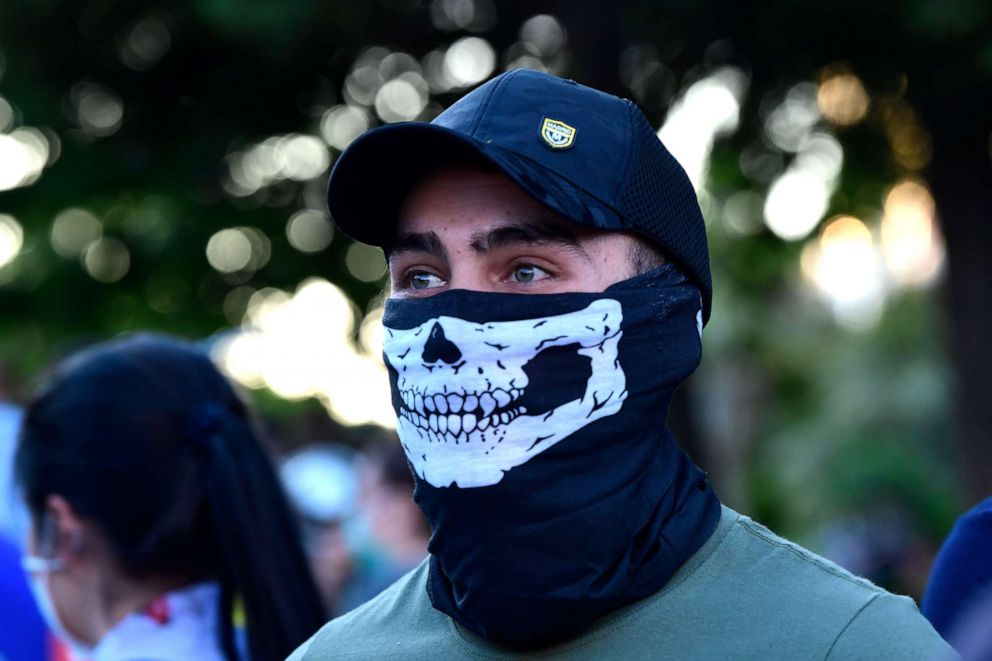 PHOTO: A demonstrator covers his face with a neck gaiter as he takes part in a demonstration against the government's handling of the coronavirus crisis, on May 20, 2020, in Alcorcon, near Madrid.