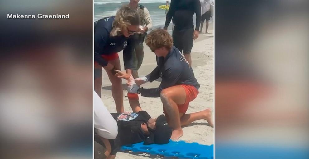 PHOTO: Matt Bender is attended to on the beach after a shark attack while surfing New Smyrna Beach in Florida.