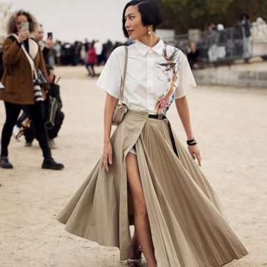 PHOTO: Molly Chiang wearing a long beige pleated maxi skirt and white shirt with ornaments outside Christian Dior, during Paris Fashion Week - Womenswear Spring/Summer 2023, Sept. 27, 2022.