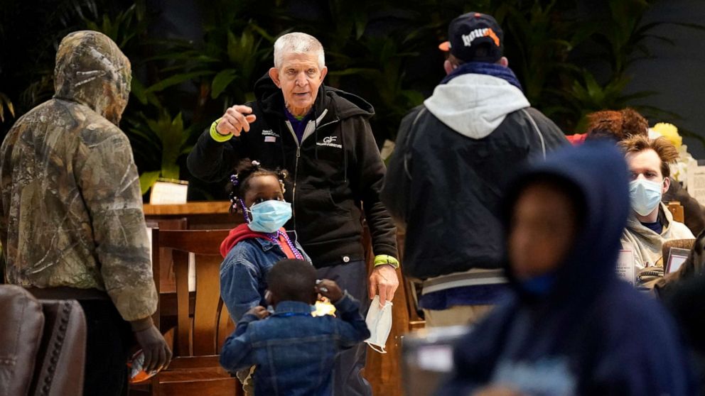 PHOTO: Owner Jim McIngvale, center, talks with people taking shelter inside his Gallery Furniture store after a cripping winter storm, Feb. 17, 2021, in Houston.