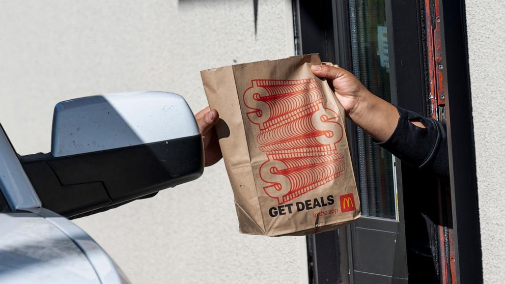 PHOTO: A worker, right, hands a customer a bag at a McDonald's restaurant in Hercules, California, Oct. 23, 2024.