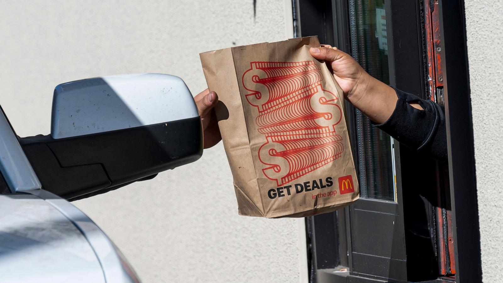 PHOTO: A worker, right, hands a customer a bag at a McDonald's restaurant in Hercules, California, Oct. 23, 2024.