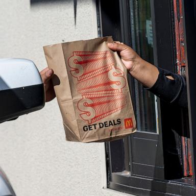 PHOTO: A worker, right, hands a customer a bag at a McDonald's restaurant in Hercules, California, Oct. 23, 2024.