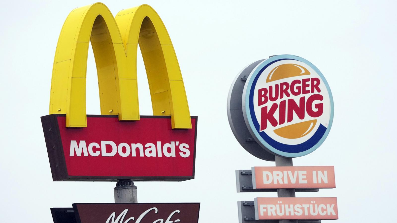 PHOTO: The logos of Mcdonald's and McCafe as well as Burger King stand next to the respective fast food restaurants at a highway rest stop, April 30, 2022.