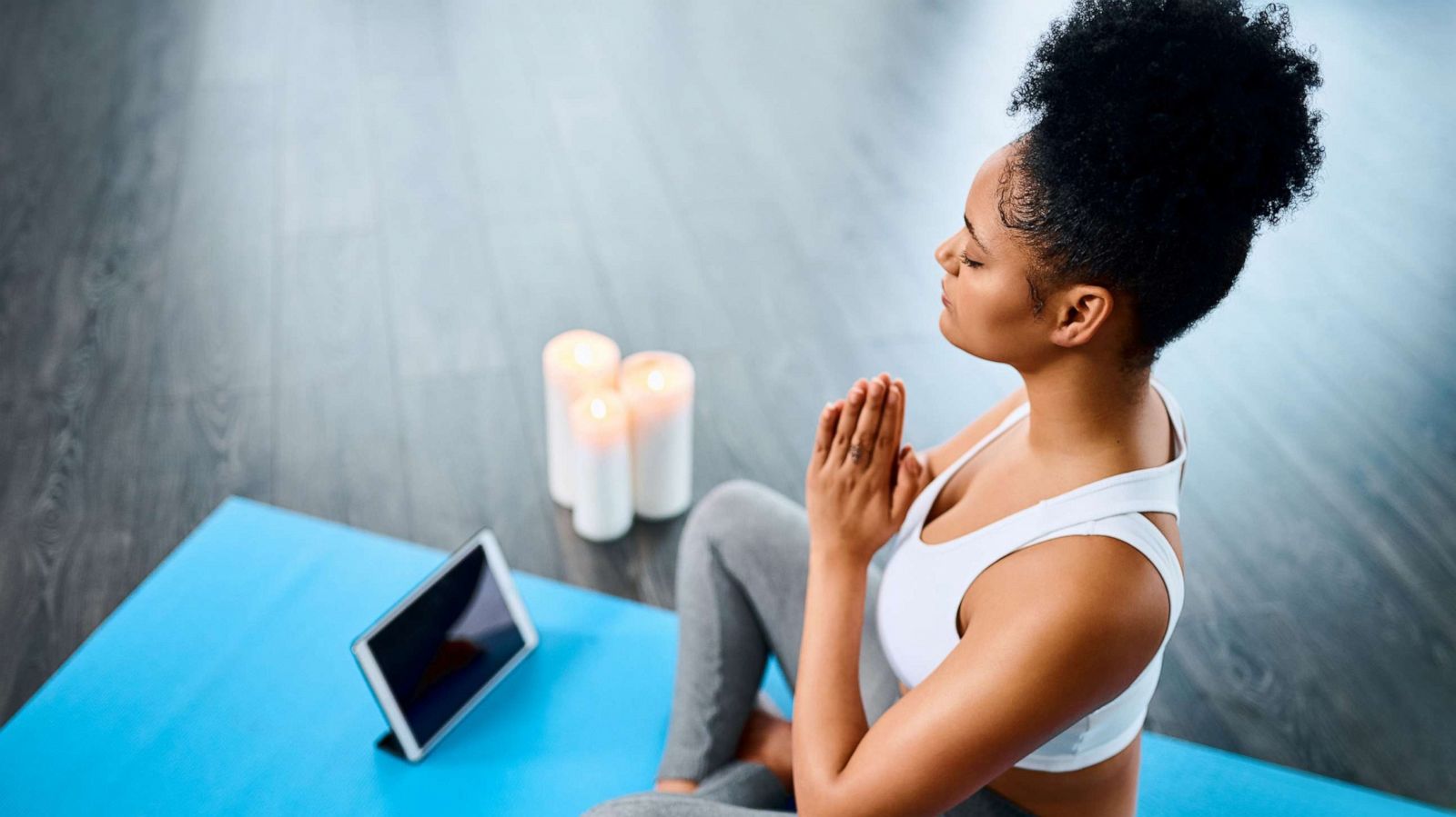 PHOTO: A young woman following yoga instructions on her digital tablet.