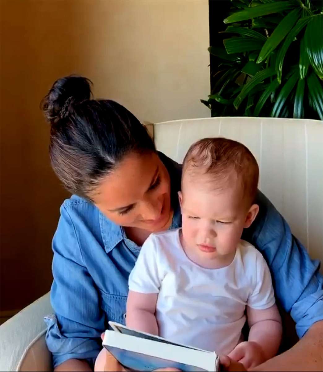 PHOTO: Meghan, Duchess of Sussex, reads a story to her son Archie in an image posted by âSave the Children UKâ on their Instagram account.
