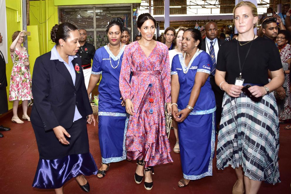 PHOTO: This handout from the Fijian Government taken and released on October 24, 2018 shows Britain's Meghan, Duchess of Sussex (C) touring the municipal market in Suva. 