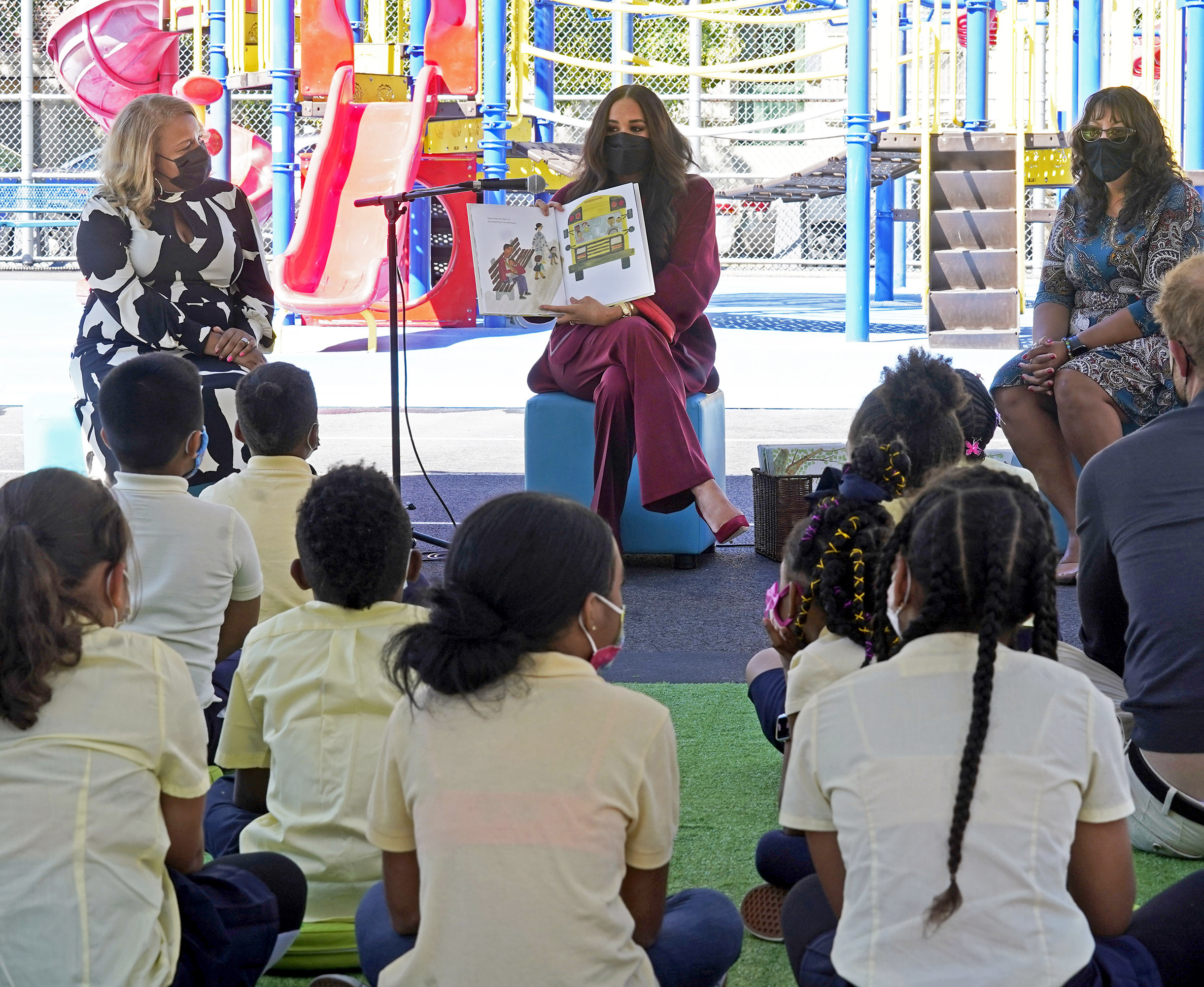 PHOTO: Meghan, the Duchess of Sussex reads from her book "The Bench," as Prince Harry, the Duke of Sussex listens along with second grade students during their visit to the Mahalia Jackson School, in New York's Harlem neighborhood, Sept. 24, 2021.