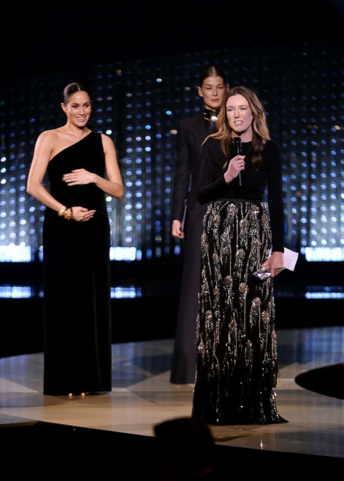 PHOTO: Clare Waight Keller is watched by Meghan, Duchess of Sussex and Rosamund Pike as she speaks after receiving the award for British Designer of the Year Womenswear Award for Givenchy during The Fashion Awards 2018 in London, Dec. 10, 2018.