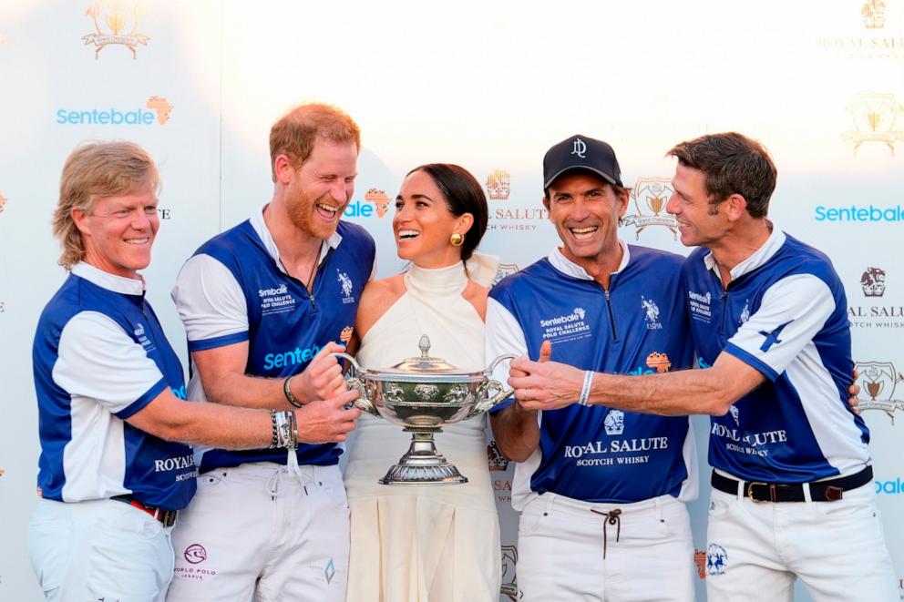 PHOTO: Britain's Prince Harry and wife Meghan Markle, Duchess of Sussex, laugh together as she presents him and his polo teammates with the trophy for winning the 2024 Royal Salute Polo Challenge on April 12, 2024, in Wellington, Fla. 