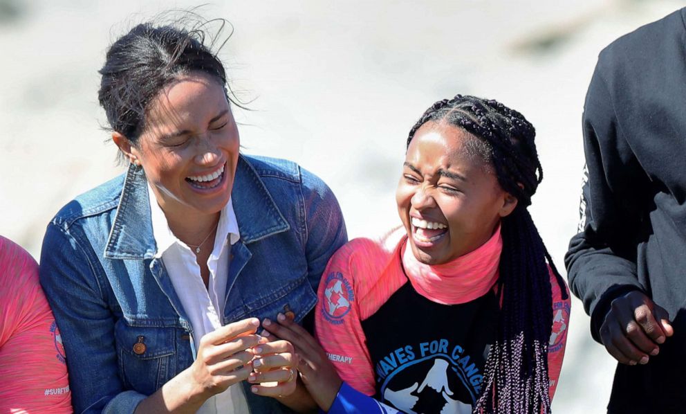 PHOTO: Meghan, the Duchess of Sussex, laughs with members of the NGO Waves for Change, during their African tour, on Monwabisi Beach in Cape Town, South Africa, Sept. 24, 2019.